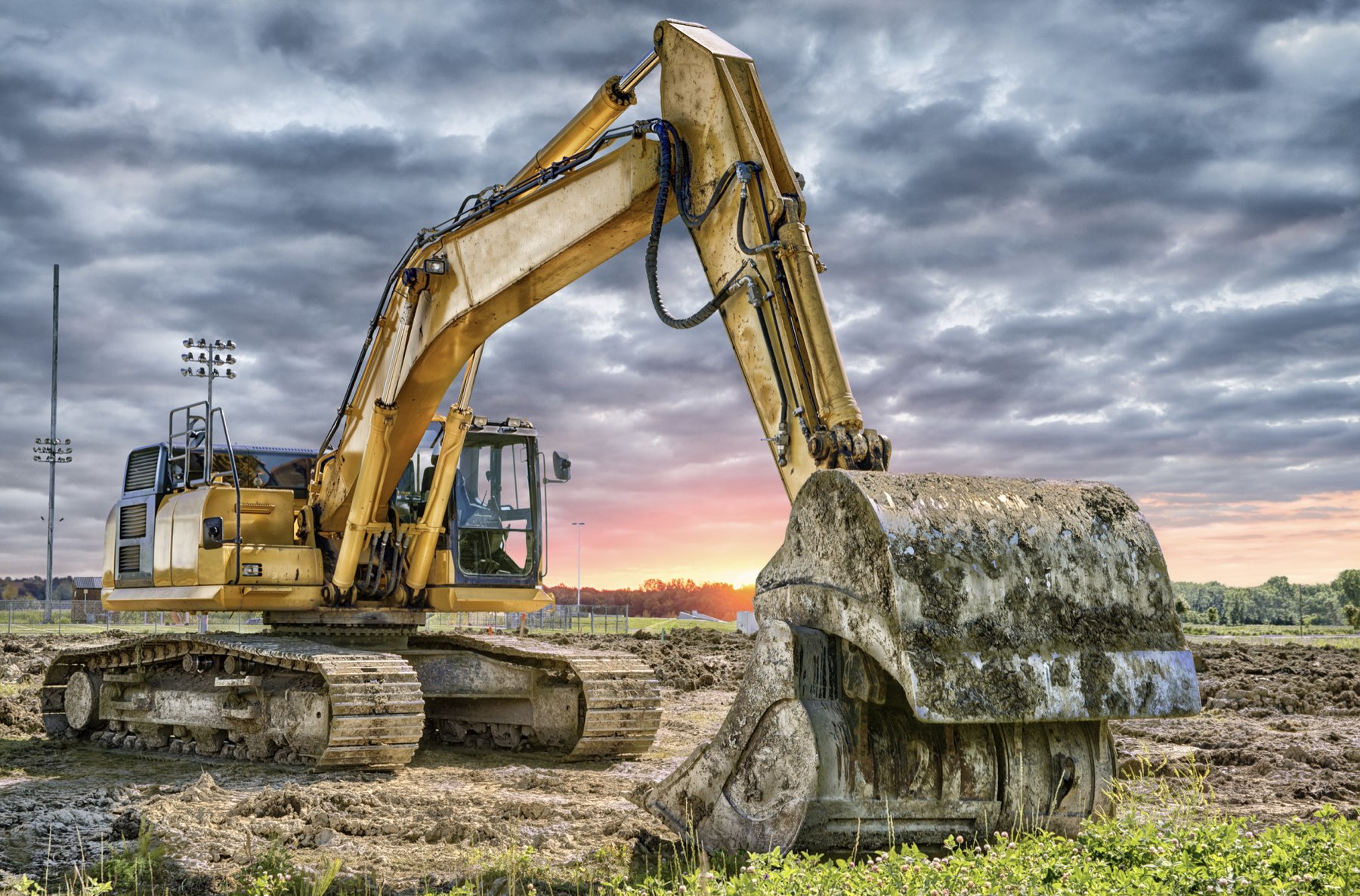 excavator machinery-construction-site-sunset-background-94511876